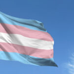 Flag representing trans awareness with blue sky background